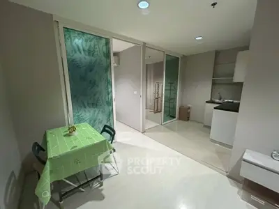Modern apartment interior with dining area and kitchen, featuring sleek design and open layout.