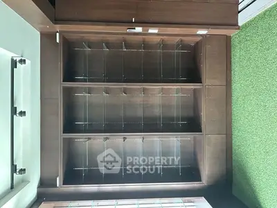 Spacious wooden storage unit with glass shelves in modern interior