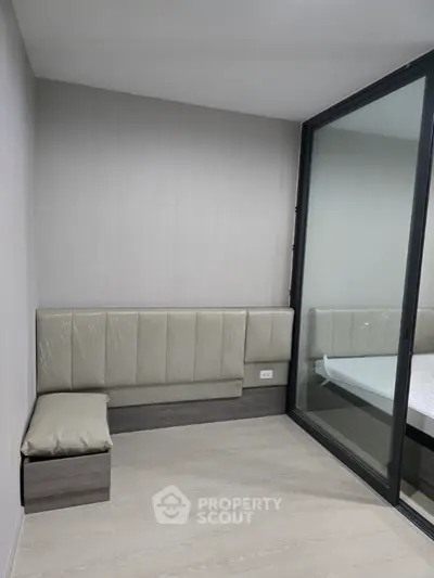 Modern minimalist room with sleek built-in seating and large mirror