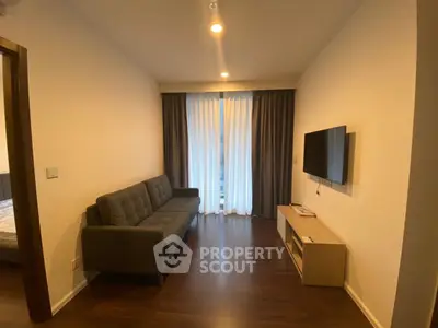 Modern living room with sleek sofa and wall-mounted TV, featuring elegant curtains and warm lighting.