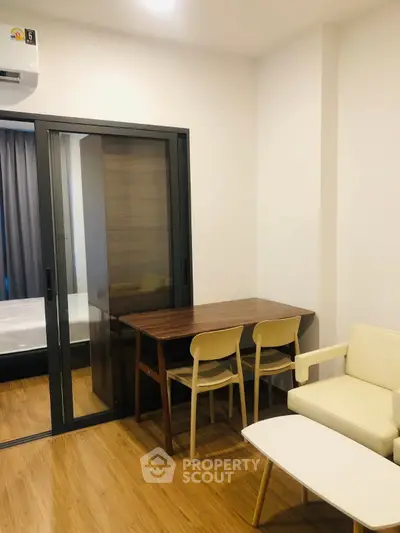 Modern living room with sliding glass door and cozy furniture in a stylish apartment.