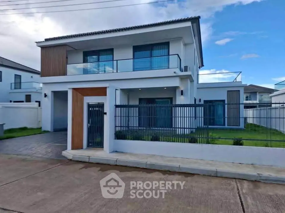 Modern two-story house with sleek design and spacious balcony in a serene neighborhood.
