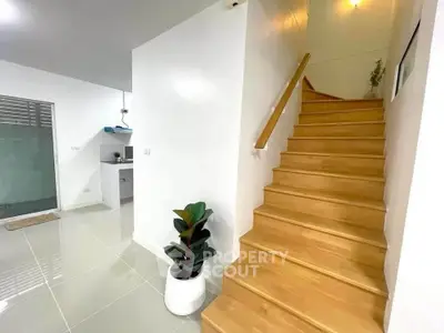 Modern interior with wooden staircase and sleek white walls, perfect for contemporary living.