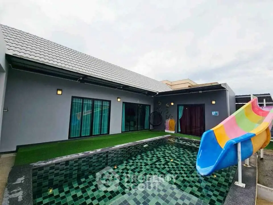 Modern home with private pool and colorful slide, perfect for family fun and relaxation.