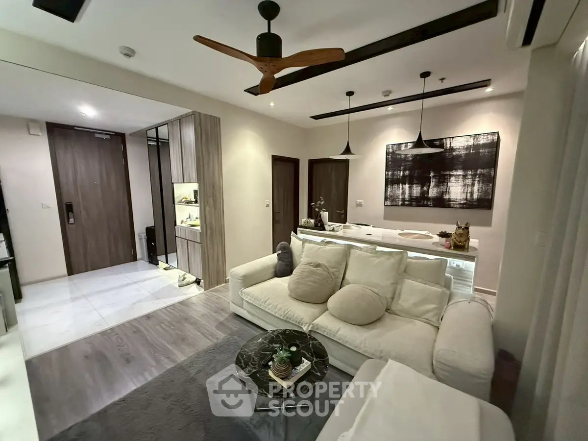 Modern living room with cozy sofa and stylish decor in open layout apartment.