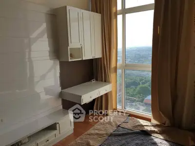 Bright bedroom with large window offering stunning city view, featuring modern built-in furniture and cozy decor.