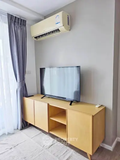 Modern living room with sleek TV stand and air conditioning, perfect for comfortable living.