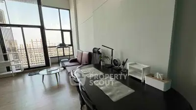 Modern living room with high ceilings and large windows offering city views.