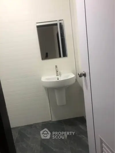 Modern bathroom with sleek sink and mirror in minimalist design.