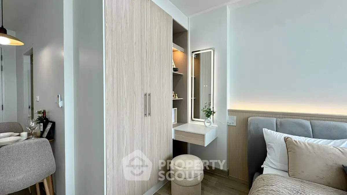 Modern bedroom with stylish wardrobe and cozy seating area in a contemporary apartment.