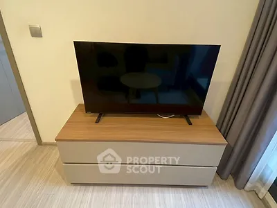 Modern living room with sleek TV on stylish wooden cabinet, perfect for cozy entertainment.