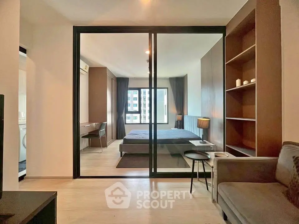 Modern apartment interior with glass partition, cozy bedroom, and stylish living area.