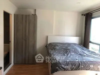Modern bedroom with large window and stylish wardrobe, perfect for urban living.