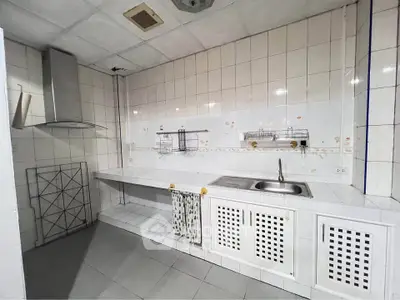 Spacious kitchen with tiled walls and modern sink in a minimalist design