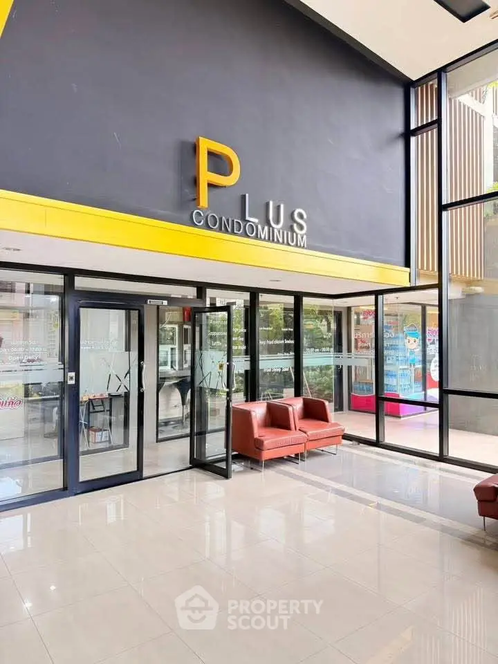Modern condominium entrance with sleek glass doors and stylish seating area.