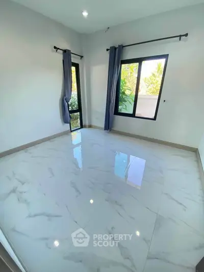 Bright empty room with large windows and marble flooring, perfect for customization.