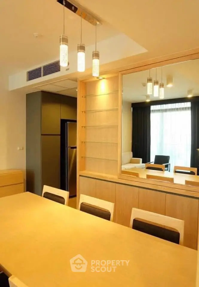 Modern dining area with elegant lighting and mirrored wall