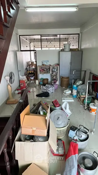 Cluttered storage room with boxes and household items, ideal for renovation and organization.
