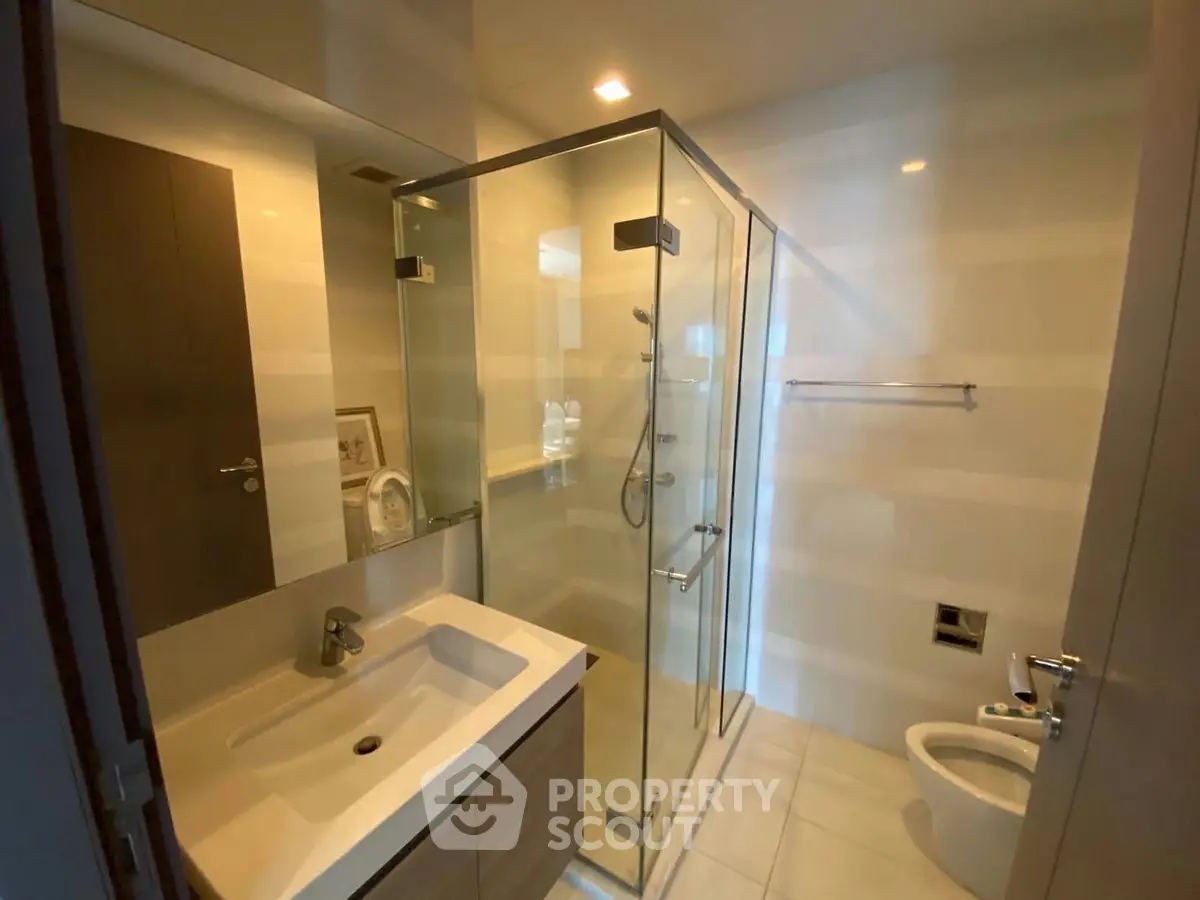 Modern bathroom with glass shower and sleek fixtures in a contemporary home.