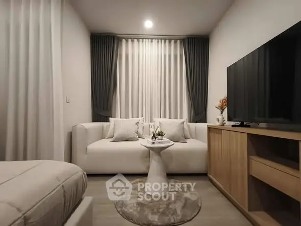 Modern living room with cozy sofa, stylish decor, and large TV for ultimate relaxation.