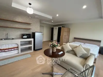 Modern studio apartment with open layout, featuring a cozy living area and compact kitchen.