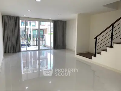 Spacious modern living room with glossy floors and large windows in a contemporary home.