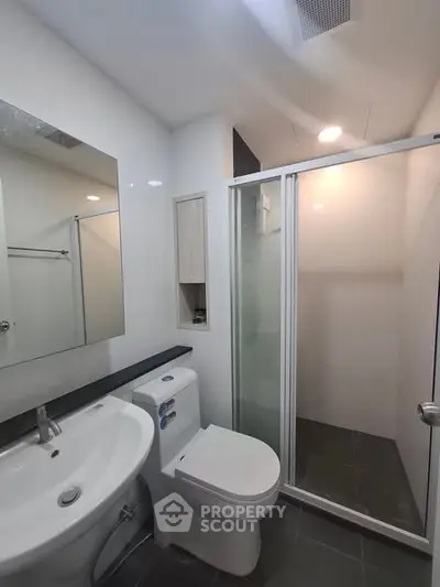 Modern bathroom with sleek fixtures and glass shower enclosure