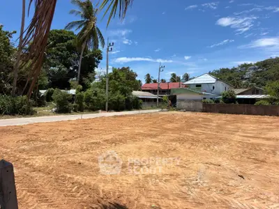 Prime land plot with lush surroundings and clear skies, ideal for development in a serene neighborhood.