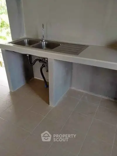 Modern kitchen with dual sink and tiled flooring, perfect for culinary enthusiasts.