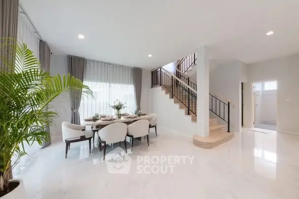 Elegant dining area with modern staircase and natural light
