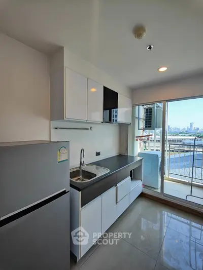 Modern kitchen with sleek cabinets and city view from balcony
