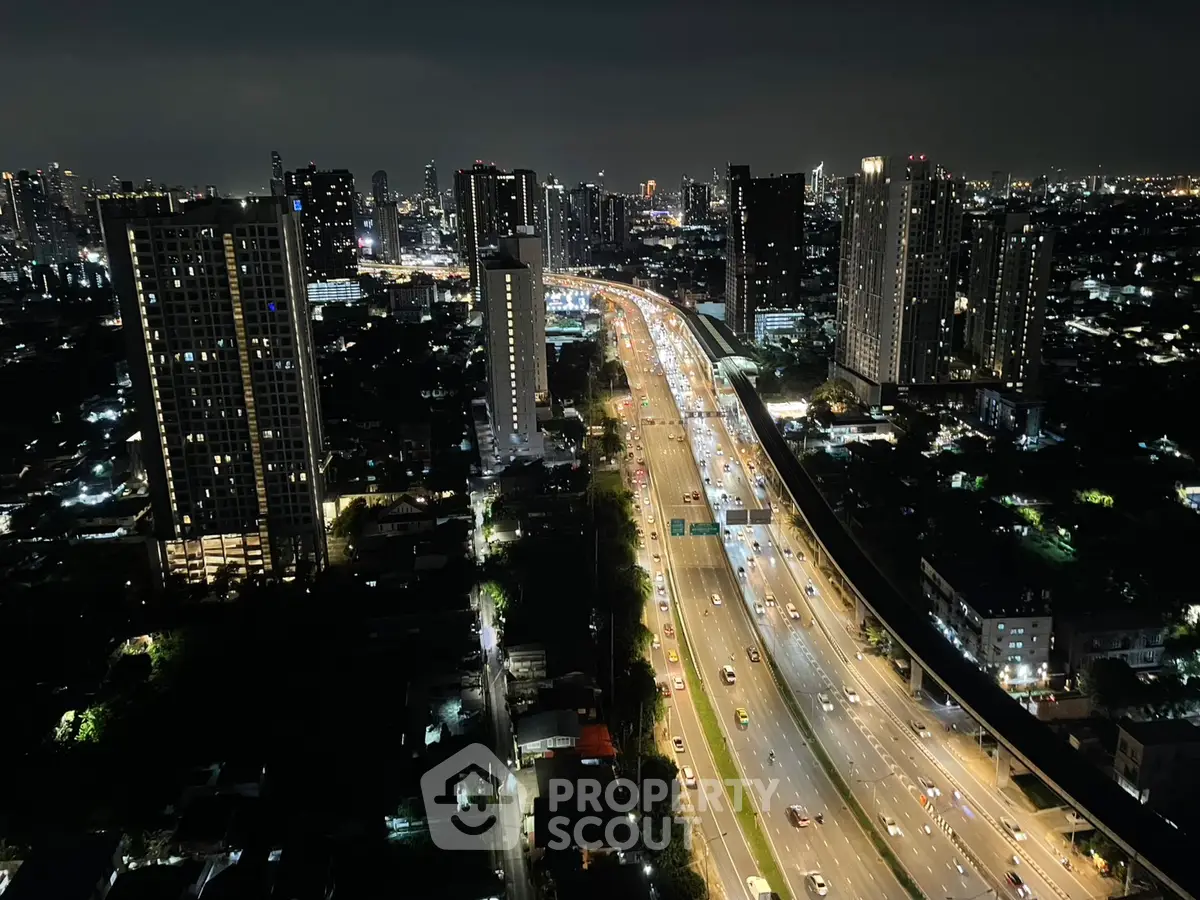 Stunning cityscape view with illuminated highway and skyscrapers at night, perfect for urban living.