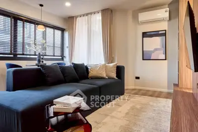 Modern living room with stylish sofa and air conditioning, featuring elegant decor and natural light.