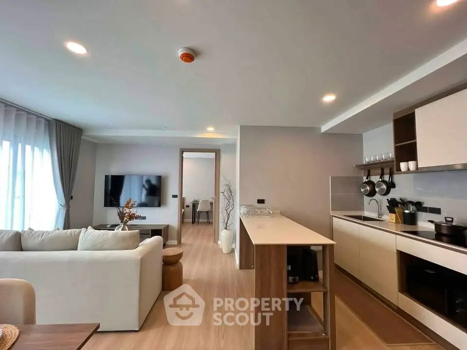 Modern open-layout living room and kitchen with sleek design and natural light