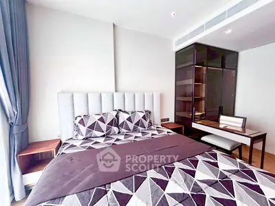 Modern bedroom with stylish geometric bedding and sleek furniture in a contemporary apartment.