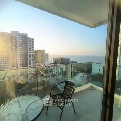 Stunning high-rise balcony with ocean view and modern glass railing.