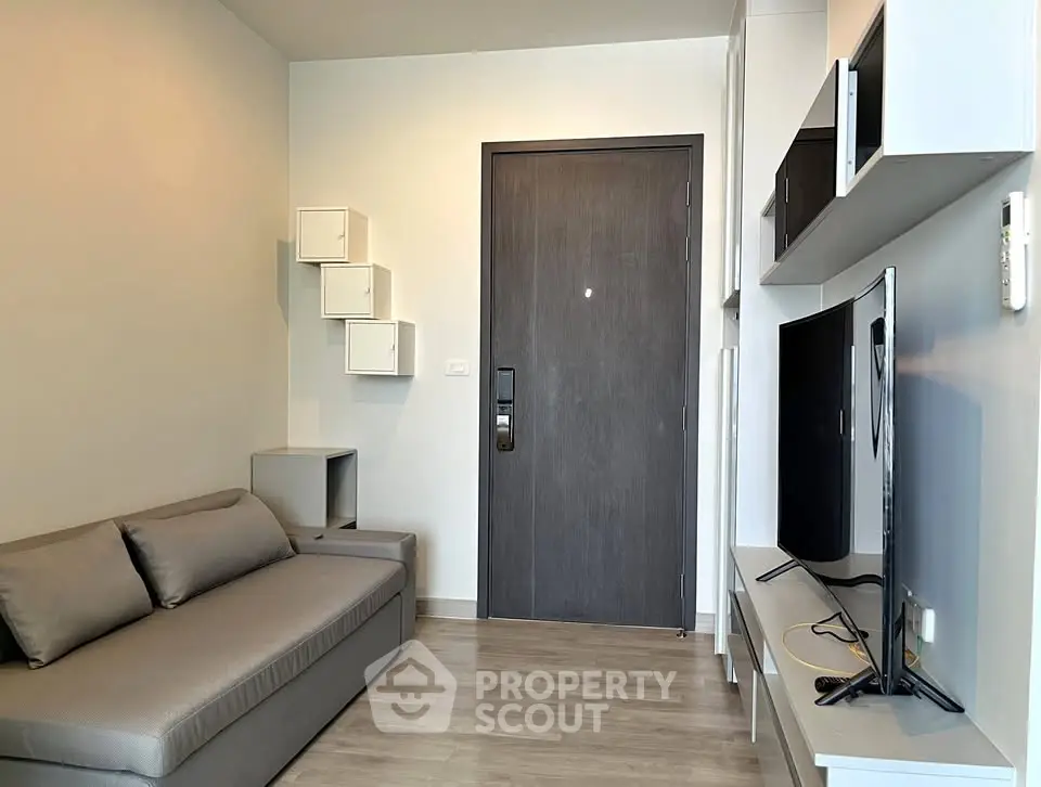 Modern living room with sleek furniture and wall-mounted TV in a stylish apartment.