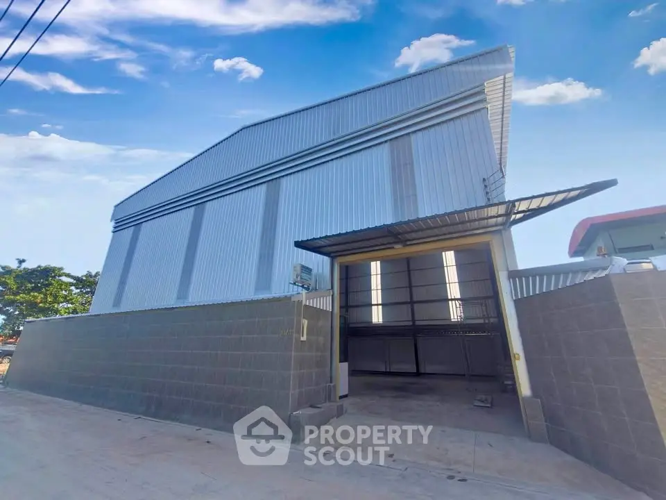 Modern industrial warehouse with spacious loading area and sleek metal exterior.