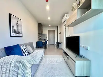 Modern living room with stylish decor and open layout, featuring a cozy sofa and sleek entertainment unit.