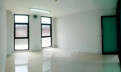 Spacious empty room with large windows and glossy tiled floor, perfect for customization.