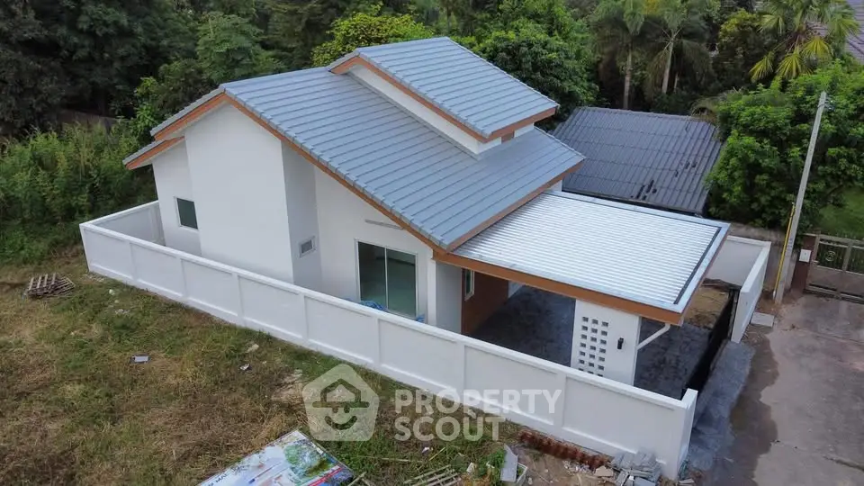 Charming modern house with sleek roof design and spacious fenced yard, perfect for family living.