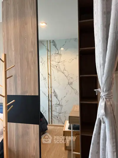 Modern bedroom with stylish wooden furniture and marble accent wall, featuring a cozy ambiance.