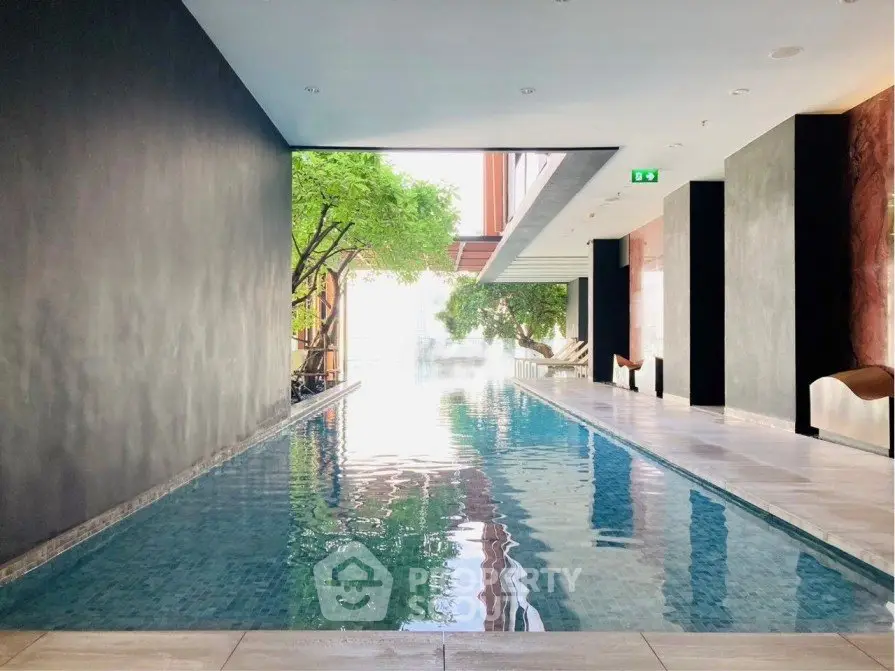 Luxurious indoor pool with modern design and natural lighting in upscale residential building.
