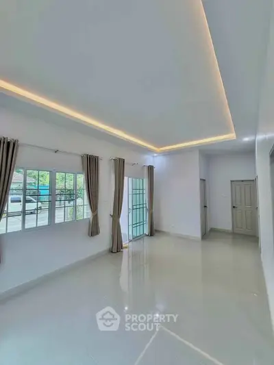 Spacious living room with modern lighting and large windows for natural light.