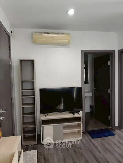 Modern living room with sleek TV stand and air conditioning unit, perfect for cozy entertainment.