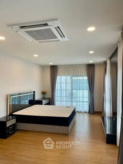 Spacious modern bedroom with large windows and elegant decor