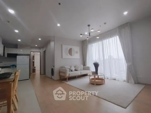 Spacious modern living room with open kitchen and natural light