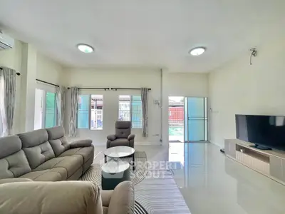 Spacious modern living room with sleek furniture and large windows offering natural light.
