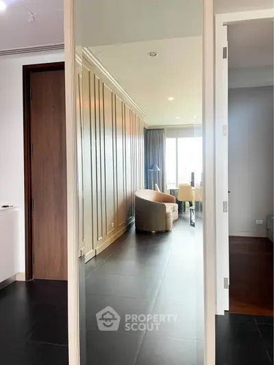 Modern living room with elegant paneling and city view, featuring stylish furniture and natural light.