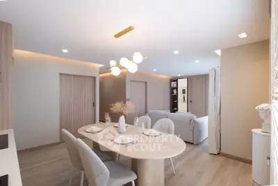 Modern open-plan living and dining area with elegant decor and stylish lighting.